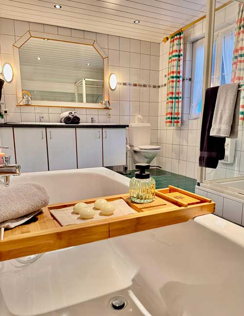 Badezimmer Detail Ferienwohnung Haus Bergharmonie Tschagguns Montafon – Badewanne und Handtücher