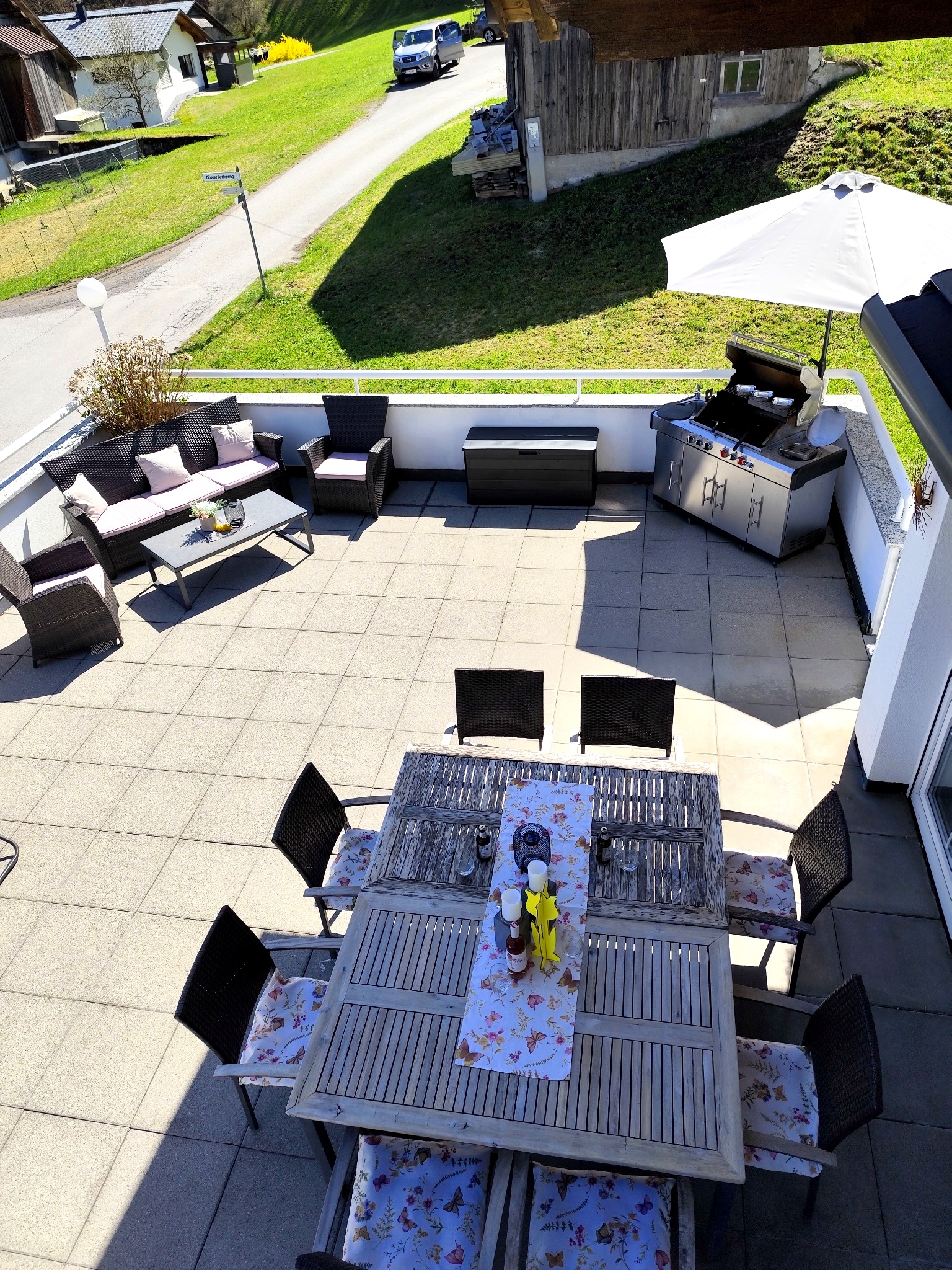 Terrasse Ferienwohnung Haus Bergharmonie Tschagguns – Essbereich, Lounge und Gasgrill von oben, Montafon