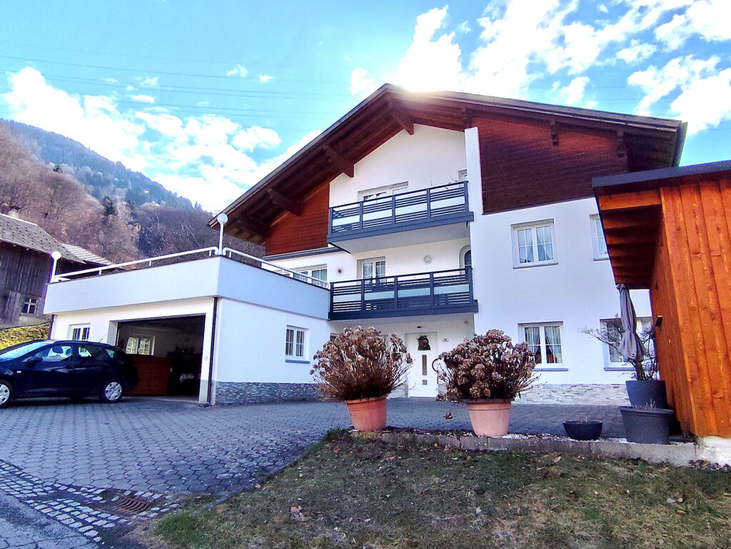 Ferienwohnung Haus Bergharmonie in Tschagguns Montafon – Außenansicht mit Garage und Balkonen