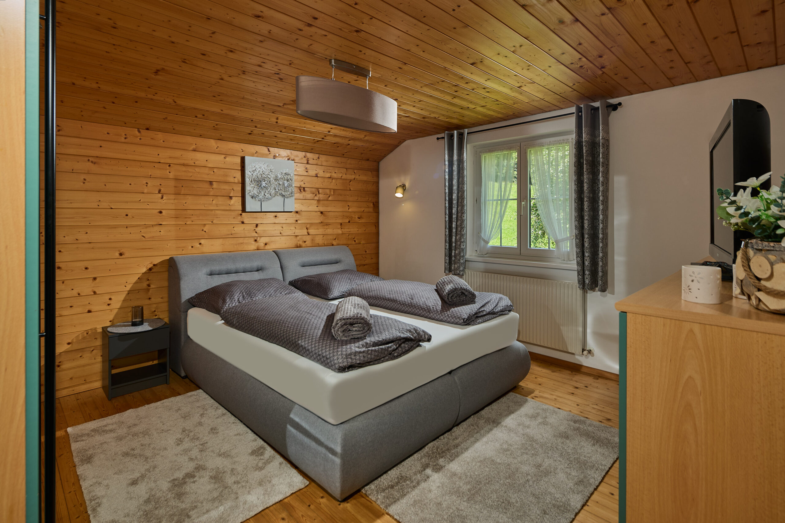 schlafzimmer-doppelbett-wandbild-fenster-panorama-blick-haus-bergharmonie-tschagguns-montafon