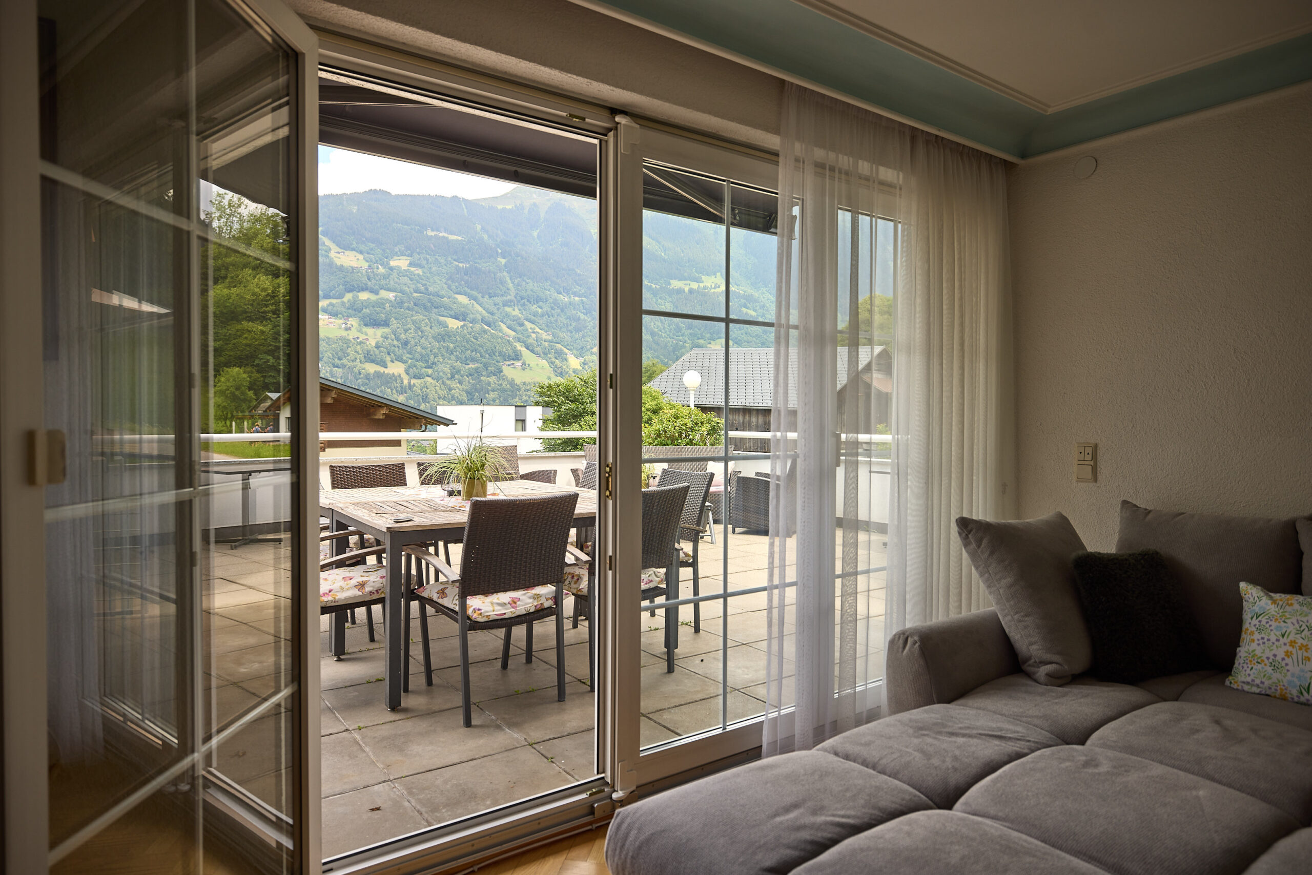 wohnzimmer-eckcouch-stuckdecke-balkontuer-panorama-blick-haus-bergharmonie-tschagguns-montafon-02