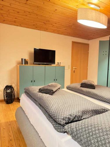 Schlafzimmer 1 Ferienwohnung Haus Bergharmonie Tschagguns Montafon – großes Doppelbett mit frischer Bettwäsche