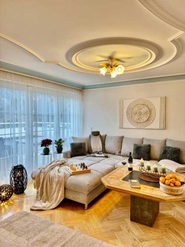 Wohnzimmer Ferienwohnung Haus Bergharmonie Tschagguns Montafon – modernes Wohnzimmer mit großem TV und Sofa