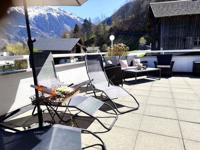 Terrasse Ferienwohnung Haus Bergharmonie Tschagguns – Liegestühle mit Aperitif und Bergpanorama Montafon