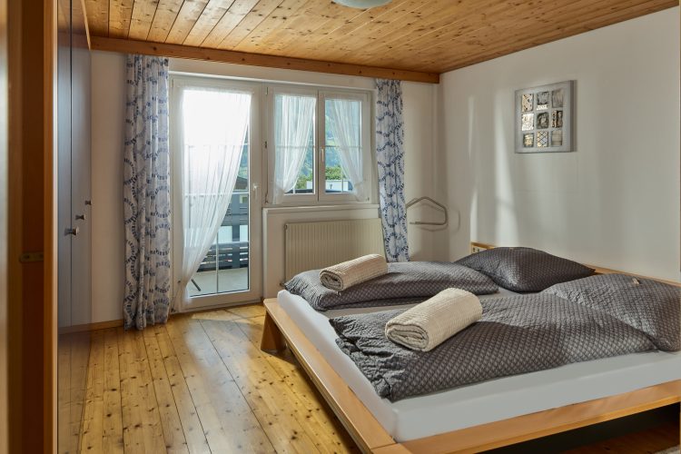 schlafzimmer-doppelbett-balkontuer-bergblick-panorama-blick-haus-bergharmonie-tschagguns-montafon