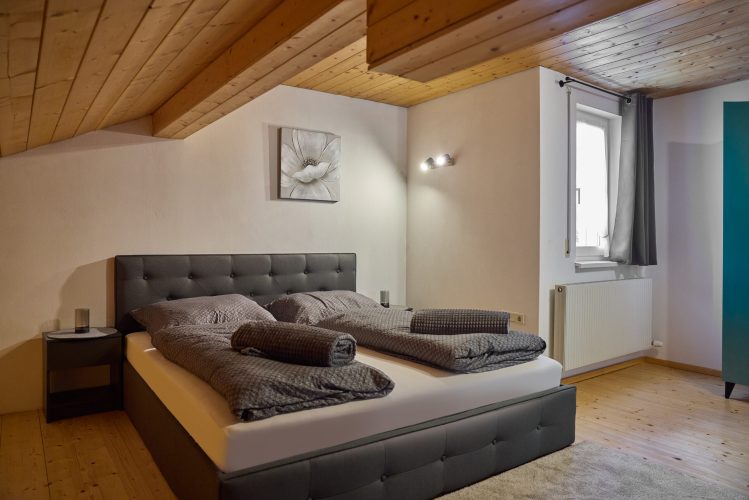 schlafzimmer-doppelbett-nachttisch-wandbild-panorama-blick-haus-bergharmonie-tschagguns-montafon